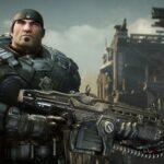 Marcus Fenix looks out past the camera while holding an assault rifle with a chainsaw attached to it.