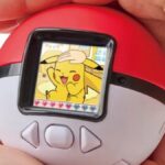 Two hands cupping the Pokemon Monster Ball.