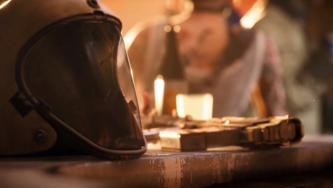 A helmet sits on a table next to a gun.