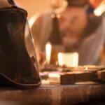 A helmet sits on a table next to a gun.
