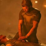 A man performs CPR on someone.