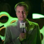 Major Nelson holds up a microphone.